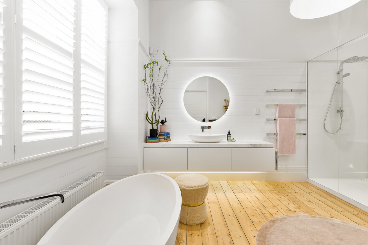 a bathroom with a mirror and a plant in the corner
