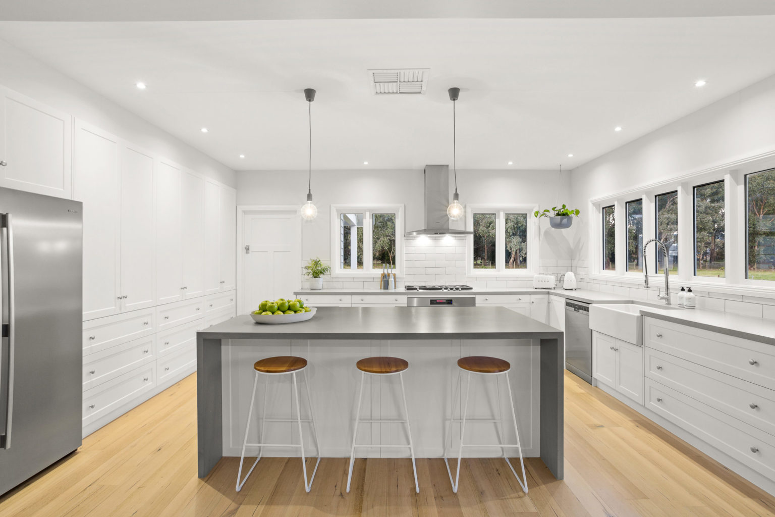 a kitchen with stools and a island