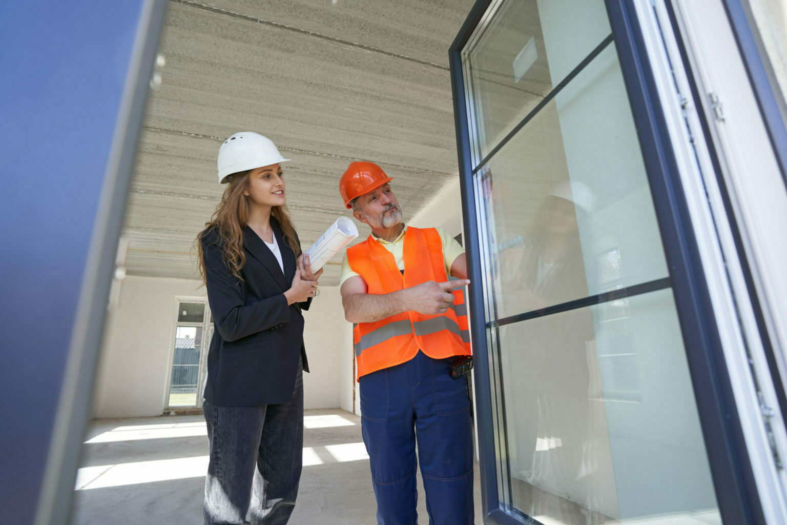 a man and woman wearing hard hats and holding a clipboard